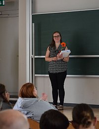 Einer Bachelor-Absolventin wurde ihr frischgedrucktes Zeugnis überreicht.